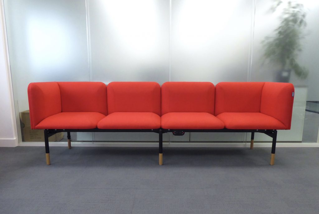 Office breakout space, with sofas upholstered in red fabric