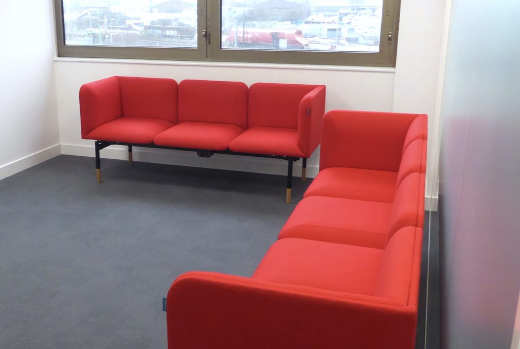 Office breakout space, with sofas upholstered in red fabric